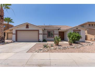 Charming single-story home featuring desert landscaping, a neutral color palette, and a two-car garage at 7205 W Ellis St, Laveen, AZ 85339