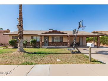 Charming single-story home with brick accents, desert landscaping, and a driveway with basketball hoop at 1263 W Del Rio St, Chandler, AZ 85224
