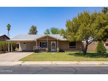 Charming single-story brick home with a covered entrance and lush green lawn at 1454 W Capri Ave, Mesa, AZ 85202