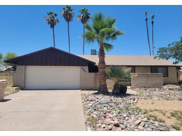 Charming single-story home featuring low-maintenance desert landscaping, palm trees, and a two-car garage at 15602 N 55Th Ave, Glendale, AZ 85306