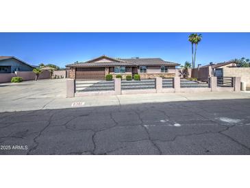Charming single-story home with a brown tile roof, desert landscaping, and a secure front fence at 1911 N 42Nd Ave, Phoenix, AZ 85009