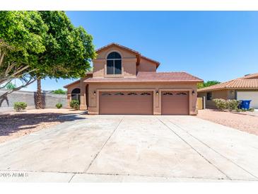 Charming home featuring a three-car garage, tiled roof, and low maintenance landscaping at 2213 N Ashbrook Cir, Mesa, AZ 85213