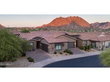 Beautiful desert home with brick driveway and stone accents, set against a majestic mountain backdrop at 26885 N 104Th Pl, Scottsdale, AZ 85262