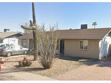 Charming single-story brick home featuring desert landscaping with gravel, cacti, and drought-resistant plants at 3227 W Lisbon Ln, Phoenix, AZ 85053