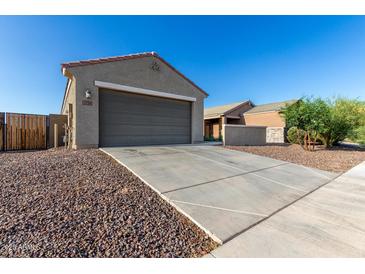 Beige home featuring a spacious garage with a long driveway and low maintenance desert landscaping at 3704 E Haflinger Rd, San Tan Valley, AZ 85140