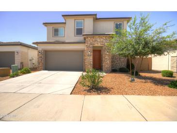 Beautiful two-story home featuring a stone facade, well-manicured landscaping, and a wide driveway with a two-car garage at 40927 W Sunland Dr, Maricopa, AZ 85138