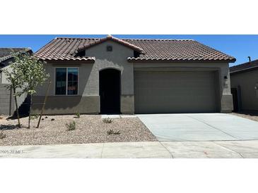 Charming single-story home featuring a tile roof, two-car garage, and low maintenance desert landscaping at 5645 S 253Rd Ave, Buckeye, AZ 85326
