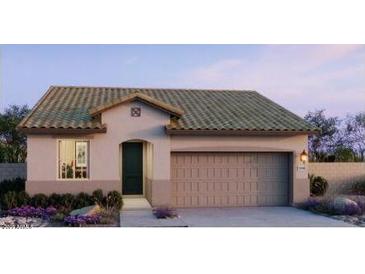 Inviting single-story home featuring a two-car garage, neutral stucco siding, and a well-manicured front garden at 5645 S 253Rd Ave, Buckeye, AZ 85326