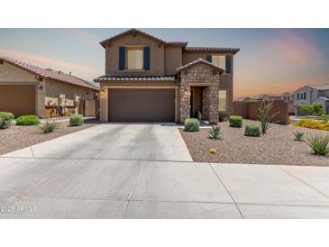 Two-story home showcasing stone accents, a two-car garage, and low-maintenance desert landscaping at 7123 W Andrea Dr, Peoria, AZ 85383