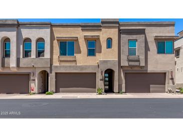 Modern townhomes with attached garages, neutral stucco, and arched entryways exude contemporary charm at 7492 E Via De Luna Dr, Scottsdale, AZ 85255