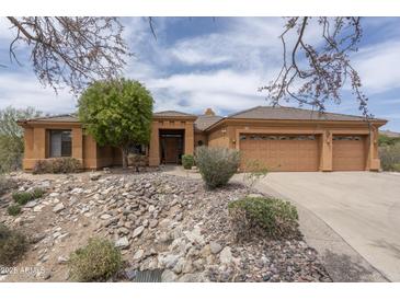 Warm, inviting home featuring a three-car garage and desert landscaping at 8698 E Preserve Way, Scottsdale, AZ 85266