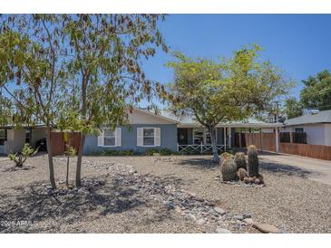 Charming home features desert landscaping, mature trees, and a covered porch with an attached carport at 1003 E Mariposa St, Phoenix, AZ 85014