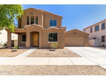 Charming two-story home with a tan exterior and a well-manicured front yard at 13617 W Crocus Dr, Surprise, AZ 85379
