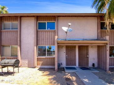 Tan two-story townhouse with brown trim, security doors, and a small front yard at 1750 E Mateo Cir # 103, Mesa, AZ 85204
