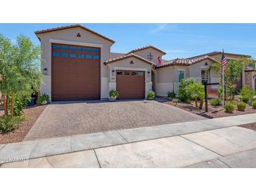 Stunning home showcasing a three-car garage, tile roof, and well-manicured landscaping at 17597 W Red Fox Rd, Surprise, AZ 85387