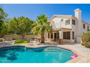 Beautiful backyard with a pool, palm tree, patio, and outdoor seating area at 1953 W Lark Dr, Chandler, AZ 85286