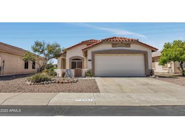 Charming single-story home featuring a two-car garage, terracotta tile roof, and desert landscaping at 23075 W Arrow Dr, Buckeye, AZ 85326