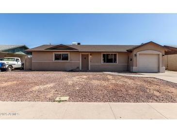 Charming single-story home featuring an attached garage and low maintenance front yard at 233 E 7Th Dr, Mesa, AZ 85210