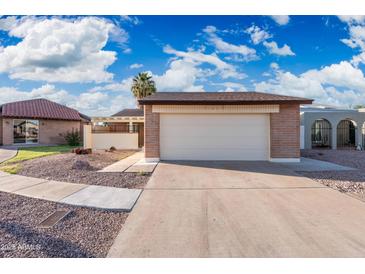 Home featuring a two-car garage, desert landscaping and brick accents on a sunny day at 4016 W Royal Palm Rd, Phoenix, AZ 85051