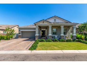 Charming home exterior featuring a covered porch, landscaped yard and brick driveway at 4442 E Fairbrook St, Mesa, AZ 85205