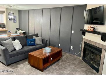 Cozy living room features a gray sofa, wooden coffee table, and decorative board and batten wall at 4601 N 102Nd Ave # 1052, Phoenix, AZ 85037