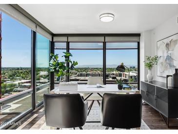 Bright home office featuring a modern desk and a wall of windows offering stunning city views at 4808 N 24Th St # 1228, Phoenix, AZ 85016