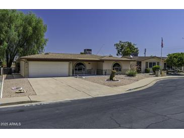 Charming home featuring a well-manicured front yard, covered entry, and attached two-car garage at 5148 E Edgewood Cir, Mesa, AZ 85206