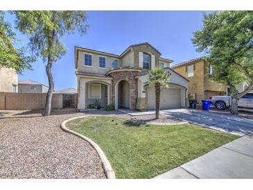 Charming two-story home featuring a stone-accented entrance, well-maintained lawn and a two-car garage at 8769 W Washington St, Tolleson, AZ 85353