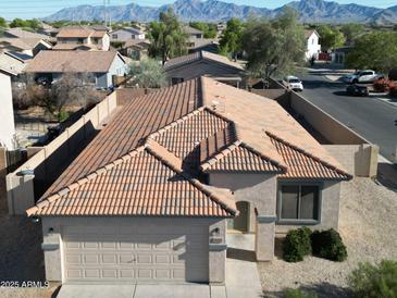 Aerial view of a single-story home with a tile roof, desert landscaping, and a two-car garage at 10429 W Miami St, Tolleson, AZ 85353