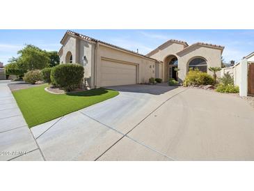 Inviting desert home with a two-car garage, manicured landscaping and a winding driveway at 11816 E Terra Dr, Scottsdale, AZ 85259