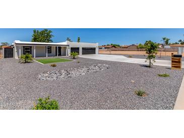 Stunning front of home featuring rock landscaping, grass patch and spacious driveway to the 2-car garage at 13012 N 36Th Dr, Phoenix, AZ 85029