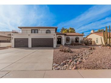 Inviting two-story home featuring a balcony, beautiful desert landscaping, and a spacious three-car garage at 15806 N 45Th Pl, Phoenix, AZ 85032