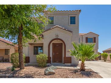 Charming two-story home with a well-manicured lawn and inviting front entrance at 17471 W Watson Ln, Surprise, AZ 85388