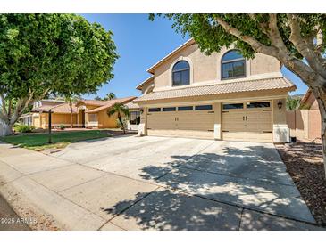Traditional two-story home featuring a three-car garage and mature landscaping at 20657 N 56Th Ave, Glendale, AZ 85308