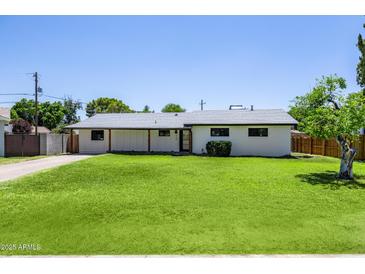 Charming single-story home with well-manicured lawn and updated neutral exterior paint at 215 W Ruth Ave, Phoenix, AZ 85021