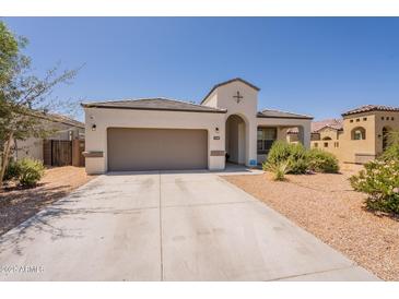 Charming home exterior featuring a two-car garage, low maintenance landscaping, and a welcoming entrance at 29481 W Mitchell Ave, Buckeye, AZ 85396