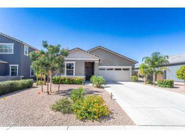 Charming single-story home boasts a neutral color, well-kept landscaping and a spacious two car garage at 36076 W Santa Barbara Ave, Maricopa, AZ 85138