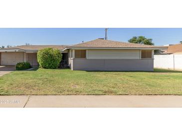 Charming single-story home features a well-maintained lawn and a classic desert landscape at 6009 W Medlock Dr, Glendale, AZ 85301