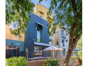 Beautiful multi-level exterior with modern architecture and a cozy outdoor patio shaded by an umbrella at 706 E Washington St # 124, Phoenix, AZ 85034