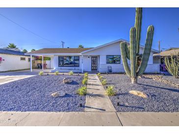 Charming single-story home featuring desert landscaping, a walkway, and a covered carport at 7428 E Cambridge Ave, Scottsdale, AZ 85257