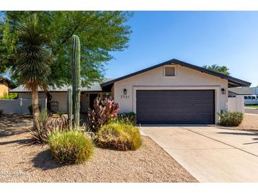 Charming home with desert landscaping, featuring a two-car garage and a well-maintained front yard at 7731 E Rose Ln, Scottsdale, AZ 85250