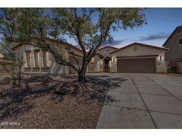 Inviting single-story home featuring a desert-landscaped front yard, private gated entry and spacious three car garage at 12360 W Eagle Ridge Ln, Peoria, AZ 85383