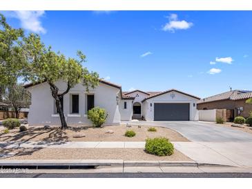Inviting single-story home featuring a well-manicured front yard and a spacious driveway leading to a two-car garage at 1720 W Aloe Vera Dr, Phoenix, AZ 85085