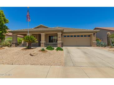 Charming single-story home featuring a neutral color scheme, well-maintained landscaping, and an American flag at 17796 W Andora St, Surprise, AZ 85388