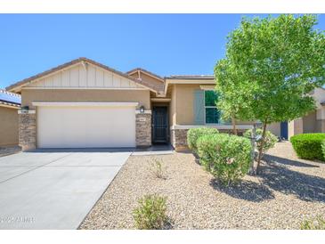 Charming home featuring a landscaped front yard, stone accents, and a two-car garage at 18027 W Tina Ln, Surprise, AZ 85387