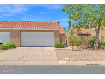Charming home featuring a two-car garage, desert landscaping, and a classic red tile roof under a sunny sky at 3510 E Hampton Ave # 18, Mesa, AZ 85204