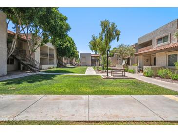 Well-maintained community grounds with lush green lawns, mature trees, and inviting walkways at 520 N Stapley Dr # 134, Mesa, AZ 85203