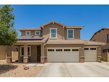Two-story home featuring a three-car garage, desert landscaping, and solar panels for energy efficiency at 7858 W Fetlock Trl, Peoria, AZ 85383