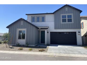 Charming two-story home featuring a dark garage door, complemented by a well-maintained front yard and clear blue sky at 9249 E Sector Dr, Mesa, AZ 85212