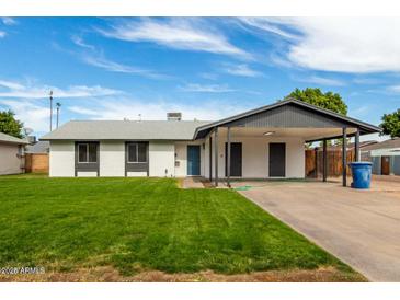 Charming single story home featuring a carport and a well-manicured lawn at 1228 E Fremont Dr, Tempe, AZ 85282